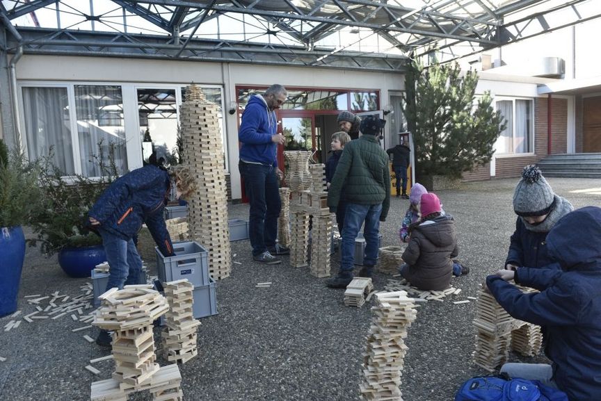 Kinder und Mitarbeiter bauen Türme